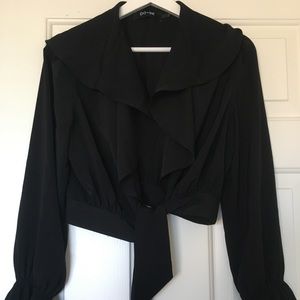 Cropped black blouse with flared sleeves.